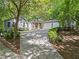Exterior view of home with a long driveway leading to a three-car garage, surrounded by lush trees at 4700 Township Walk, Marietta, GA 30066