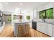 Modern kitchen with white cabinets, wooden floors, and an island; bright and spacious at 4700 Township Walk, Marietta, GA 30066