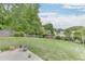 Expansive backyard with lush greenery, wooden fence, swing, and concrete patio, perfect for outdoor enjoyment at 5555 Sugar Crossing Dr, Sugar Hill, GA 30518