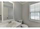 Powder room featuring a vanity, toilet, and window at 5555 Sugar Crossing Dr, Sugar Hill, GA 30518