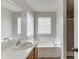Bathroom featuring a vanity with wood cabinets and a soaking tub at 5555 Sugar Crossing Dr, Sugar Hill, GA 30518