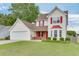 Beautiful two-story home with a two-car garage, complemented by a lush green lawn at 5555 Sugar Crossing Dr, Sugar Hill, GA 30518