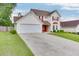 Inviting two-story home with red shutters, lush lawn, and a spacious two-car garage at 5555 Sugar Crossing Dr, Sugar Hill, GA 30518