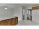 Bright eat-in kitchen area with white paneled walls, white tile floor, and wood cabinets at 5555 Sugar Crossing Dr, Sugar Hill, GA 30518