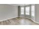 Bright, open living room with bay windows and modern wood-look floors for easy maintenance at 5555 Sugar Crossing Dr, Sugar Hill, GA 30518