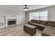 Living room with a gray couch, gray ottoman and fireplace with decorative tile at 5555 Sugar Crossing Dr, Sugar Hill, GA 30518