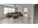 Living room with a gray couch, gray ottoman and fireplace with decorative tile, and view of kitchen at 5555 Sugar Crossing Dr, Sugar Hill, GA 30518