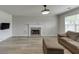 Bright living room with a fireplace, modern flooring, and comfortable seating at 5555 Sugar Crossing Dr, Sugar Hill, GA 30518