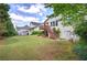 Spacious backyard with lush green lawn, mature trees, and a charming wood deck and stairs at 116 Patrick Way, Marietta, GA 30064
