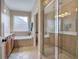 Well-lit bathroom with a glass-enclosed shower and bathtub and window at 116 Patrick Way, Marietta, GA 30064