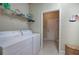 The laundry room includes a washer and dryer, storage shelves and tiled flooring at 116 Patrick Way, Marietta, GA 30064