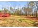 Grassy backyard with a red deck and treeline at 12348 Hillcrest Dr, Hampton, GA 30228