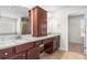 Bathroom with granite counters, double sinks, wooden cabinets and an open door to a walk-in closet at 12348 Hillcrest Dr, Hampton, GA 30228