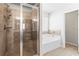 Well-lit bathroom featuring tiled shower with glass door and separate soaking tub with tile surround at 12348 Hillcrest Dr, Hampton, GA 30228