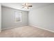 Neutral carpeted bedroom with ceiling fan and a window providing natural light at 12348 Hillcrest Dr, Hampton, GA 30228