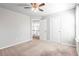 Carpeted bedroom featuring a window, walk-in closet, and view of railing and living space at 12348 Hillcrest Dr, Hampton, GA 30228