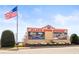 View of Atlanta Motor Speedway entrance sign under a clear sky and an American flag waving at 12348 Hillcrest Dr, Hampton, GA 30228