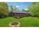 Wide backyard featuring a fire pit and the back of the house with a deck at 1280 Gin House Ln, Lawrenceville, GA 30045