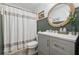 Charming bathroom showcasing modern vanity, round mirror, updated fixtures and decorative shower curtain at 1280 Gin House Ln, Lawrenceville, GA 30045