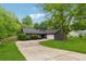 Exterior view showcasing the home's dark gray siding, well-kept lawn, and a spacious driveway at 1280 Gin House Ln, Lawrenceville, GA 30045