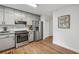 Bright kitchen with stainless steel appliances, gray cabinets and new hardwood floors at 1280 Gin House Ln, Lawrenceville, GA 30045