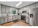 Contemporary kitchen with stainless steel appliances, granite countertops, and gray cabinetry at 1280 Gin House Ln, Lawrenceville, GA 30045