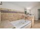 This bathroom includes a tiled deck-mounted tub, tiled walls, and double sink vanity at 1627 Isham Dr, Lawrenceville, GA 30046