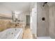 Bathroom showcasing tub with jets and separate tiled shower at 1627 Isham Dr, Lawrenceville, GA 30046