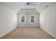 Large bedroom has tray ceilings, ceiling fan, and two windows at 1627 Isham Dr, Lawrenceville, GA 30046