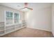 Bedroom with carpet, ceiling fan, window, and built-in shelves at 1627 Isham Dr, Lawrenceville, GA 30046