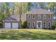 Charming home with a two-car garage, well-manicured lawn, and mature trees offering great curb appeal at 1627 Isham Dr, Lawrenceville, GA 30046
