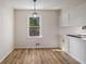 Eat-in kitchen with hardwood flooring, window, and white cabinets at 1627 Isham Dr, Lawrenceville, GA 30046