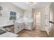 Bright kitchen featuring stainless appliances, white cabinets, quartz counters, subway tile and hardwood floors at 1627 Isham Dr, Lawrenceville, GA 30046