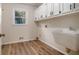 Clean laundry room with window, sink, and laminate floors at 1627 Isham Dr, Lawrenceville, GA 30046