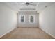 Bright main bedroom with tray ceiling, fan, carpet, and two windows at 1627 Isham Dr, Lawrenceville, GA 30046
