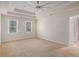 Spacious main bedroom with tray ceiling, fan, carpet, and two windows at 1627 Isham Dr, Lawrenceville, GA 30046