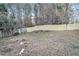 A fenced-in backyard, mostly bare with trees, leaves, and space for landscaping at 3918 S Creek Ct, Stone Mountain, GA 30083