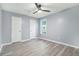 This bedroom features a ceiling fan, light gray walls, laminate flooring, and a bright window at 3918 S Creek Ct, Stone Mountain, GA 30083