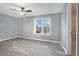 Serene bedroom with wood-look flooring, a ceiling fan, and a large window for natural light at 3918 S Creek Ct, Stone Mountain, GA 30083