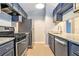 Well-equipped kitchen with stainless steel appliances, granite countertops, and updated blue cabinetry at 3918 S Creek Ct, Stone Mountain, GA 30083