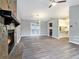 Open-concept living room featuring a stone fireplace, wood-look flooring, and access to the kitchen and backyard at 3918 S Creek Ct, Stone Mountain, GA 30083