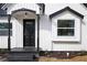 Front door with black trim and accent window, complimented by landscaping and fresh mulch at 65 Sage St, Temple, GA 30179