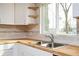Bright kitchen features wooden countertops, stainless steel sink, and corner wooden shelves at 65 Sage St, Temple, GA 30179
