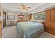 Carpeted main bedroom featuring a large bed, built-in cabinets, and ceiling fan at 2062 Cezar Nw Dr, Kennesaw, GA 30152