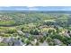 An aerial view showcasing a neighborhood surrounded by lush greenery, mature trees, and a golf course in the distance at 2400 Gants Hill Pl, Cumming, GA 30041