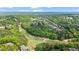 Scenic aerial view of homes surrounded by lush forests and a green golf course in the distance at 2400 Gants Hill Pl, Cumming, GA 30041
