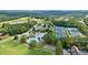 An aerial view of a community featuring tennis courts, a pool, and a clubhouse nestled among mature trees at 2400 Gants Hill Pl, Cumming, GA 30041