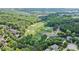 An aerial view showcasing a verdant golf course surrounded by mature trees and residential homes within a well-planned community at 2400 Gants Hill Pl, Cumming, GA 30041