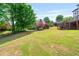 Expansive backyard featuring lush lawn, mature trees, and a view of the home's exterior at 2400 Gants Hill Pl, Cumming, GA 30041