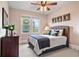 Cozy bedroom with ceiling fan, carpeted floor, and natural light from a double window at 2400 Gants Hill Pl, Cumming, GA 30041